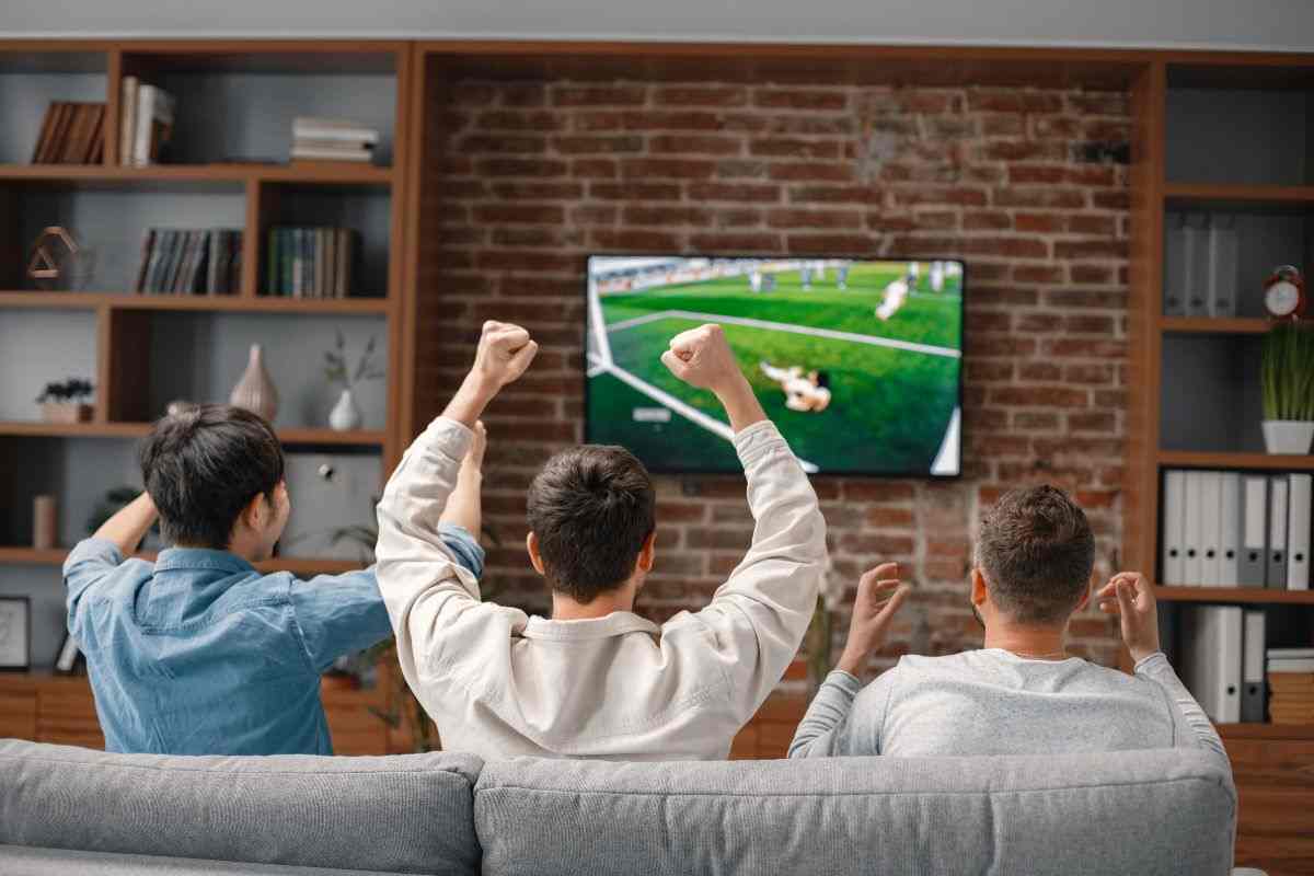 ragazzi che guardano una partita di calcio in tv